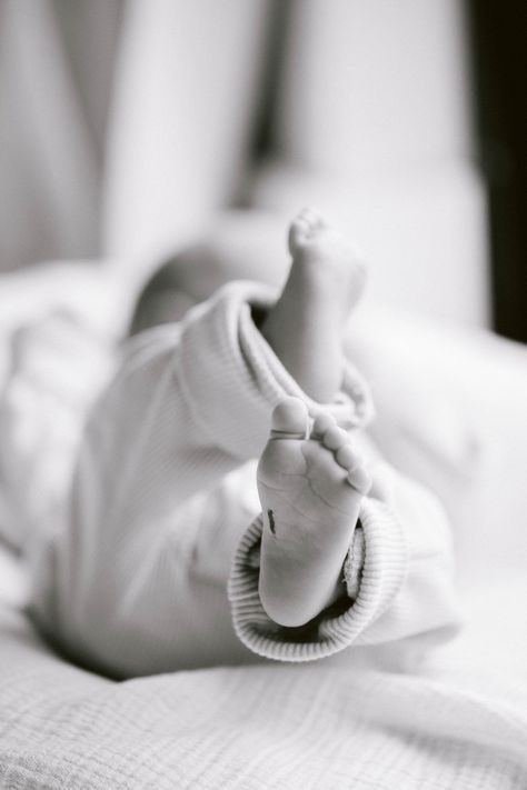 What to expect at your newborn photo session: sleeping baby's feet peeking from a soft blanket